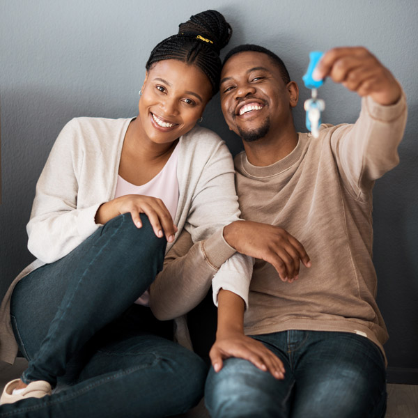 new homeowners sitting on floor holding keys